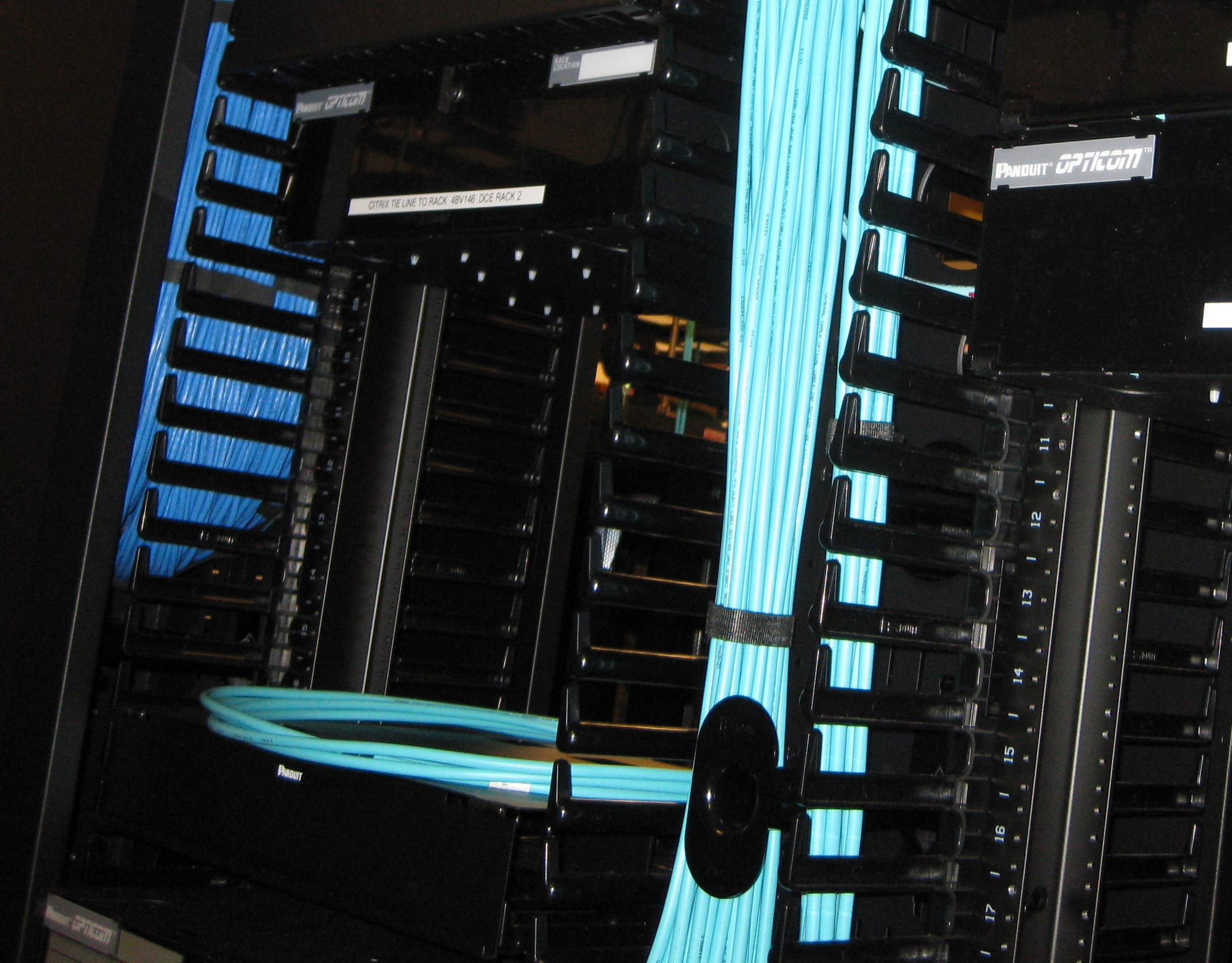 Fiber patch panel mounted in a 19-inch rack with slack coiled behind the door.