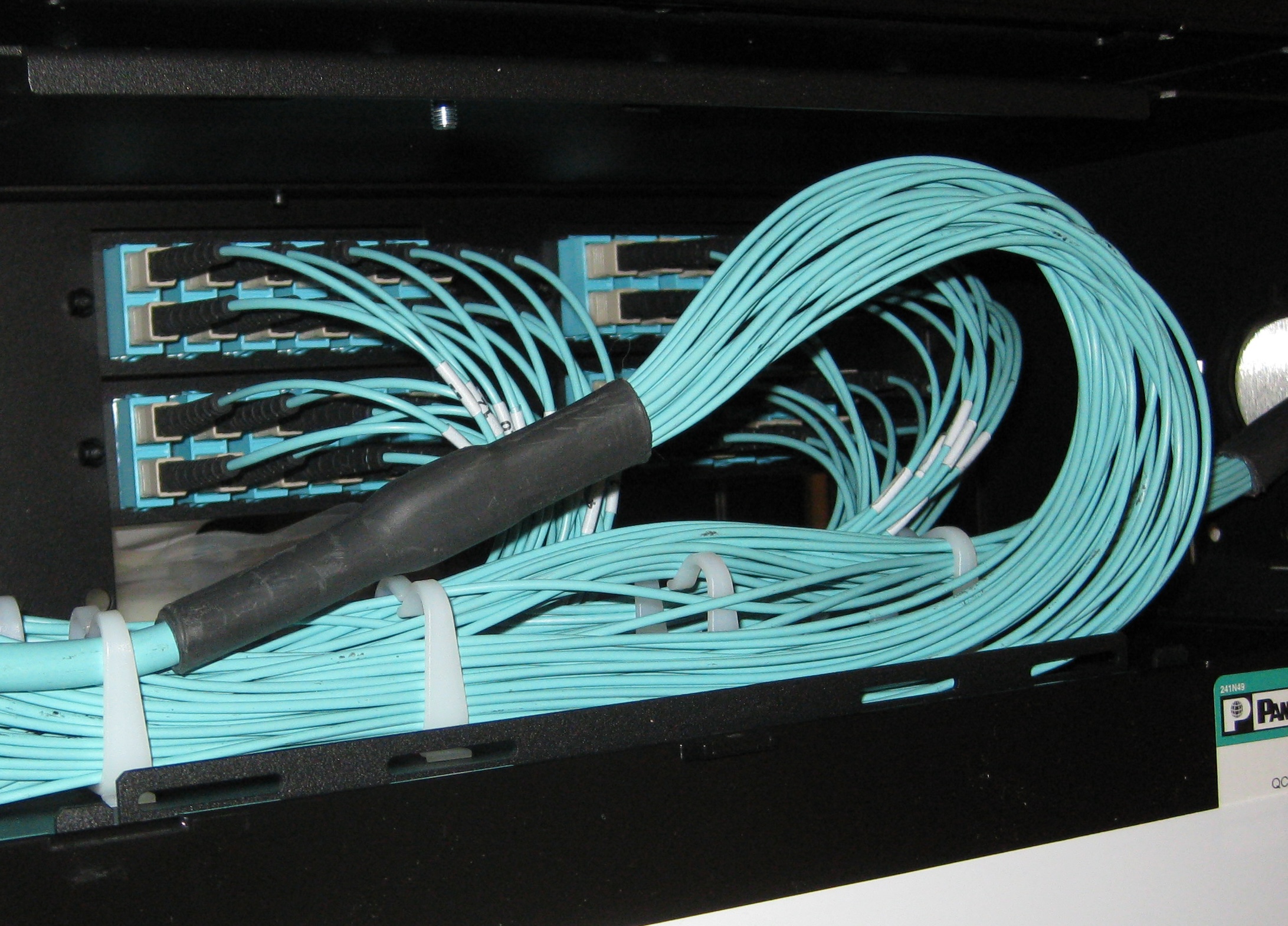 High-density fiber distribution panel with LC connectors and yellow jumpers dressed in order.
