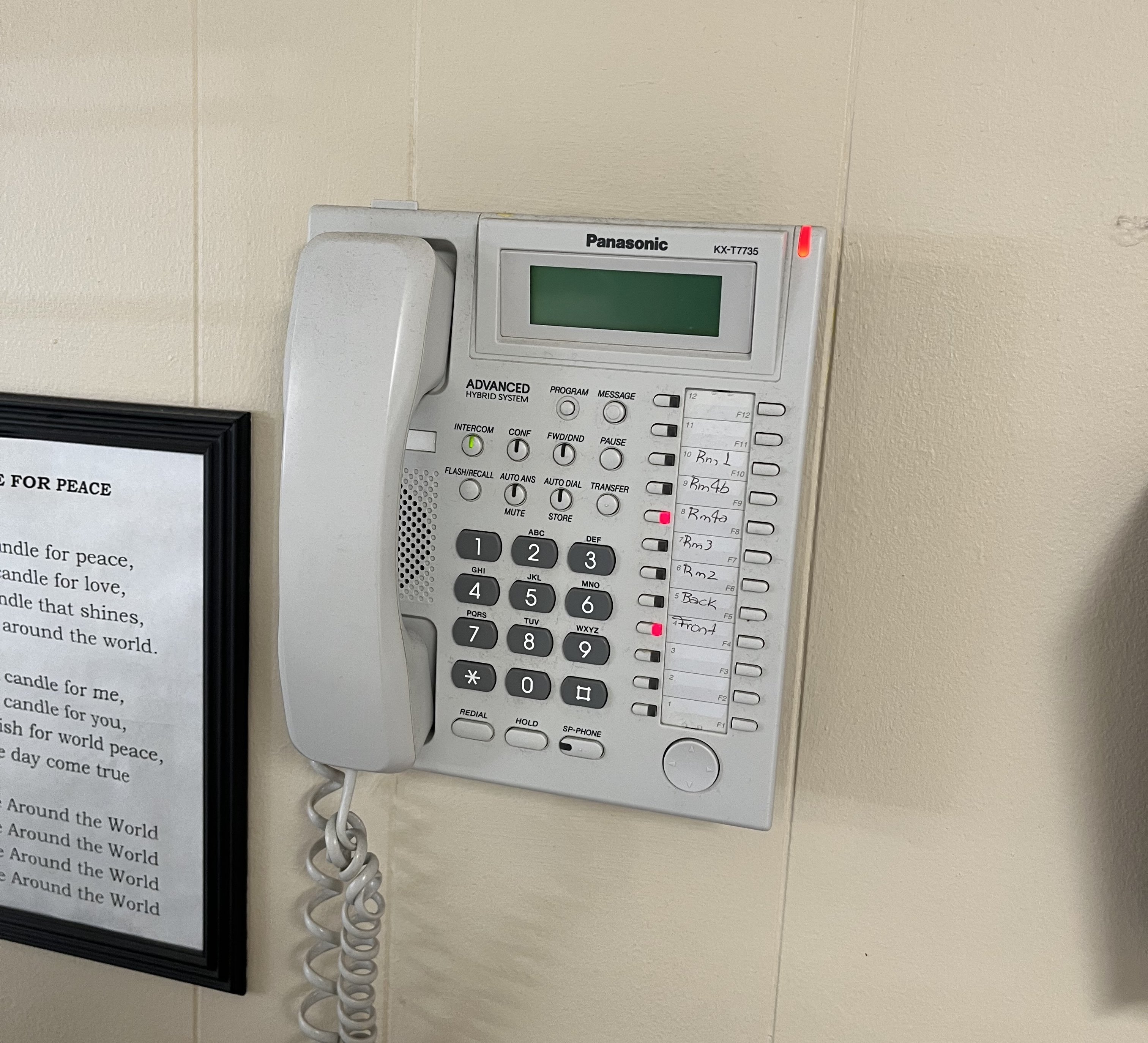 Panasonic KX-T7735 wall phone with hand-labeled line keys for individual rooms.